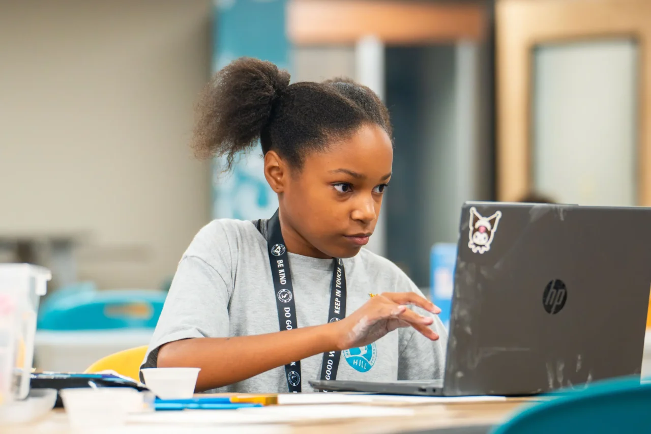 Student focused on a laptop, illustrating programs at Cyber Academy or Heron Virtual for one community.