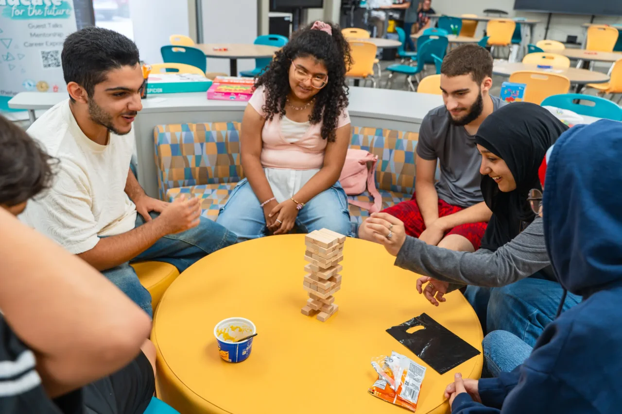 Students at The HILL engaged in a Jenga game, fostering one community spirit and collaboration.