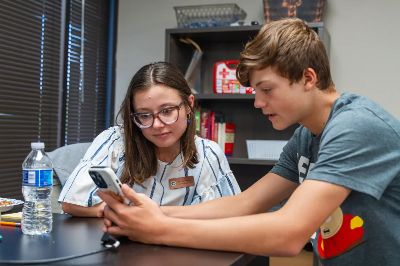 Student receiving academic support from a staff member at a virtual school, focusing on structured help.