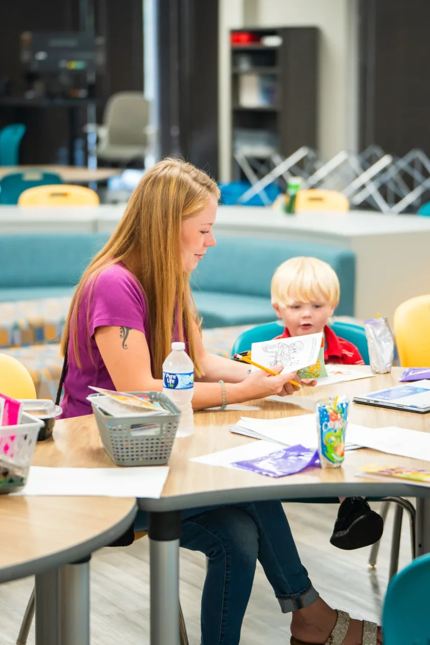 A woman and child engaged in learning activities, promoting in-person support and connection at Cyber Academy.