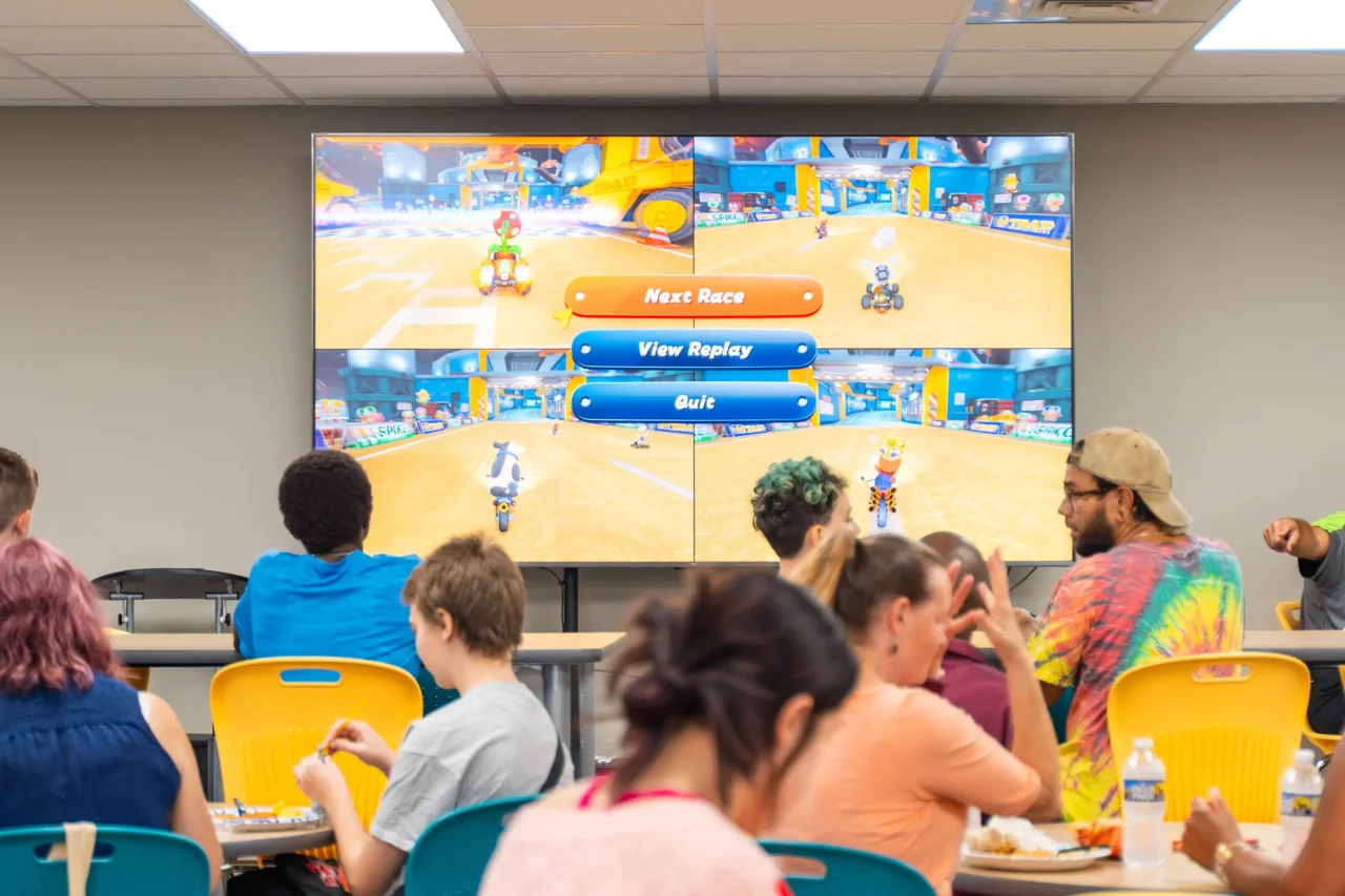 Students at Heron Virtual Academy enjoying a video game session, highlighting in-person connection.