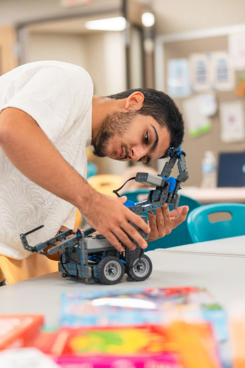 Student engaged in building a robotic device in a learning space designed for different ages and growth.