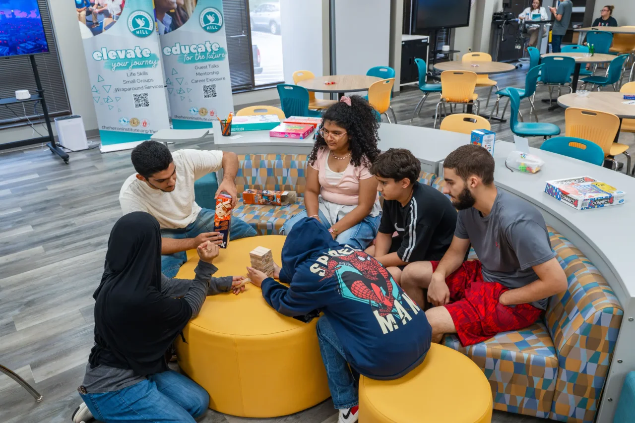 Academy students in Greenville's Hill learning lab engage in a Jenga game, fostering connection and interaction.
