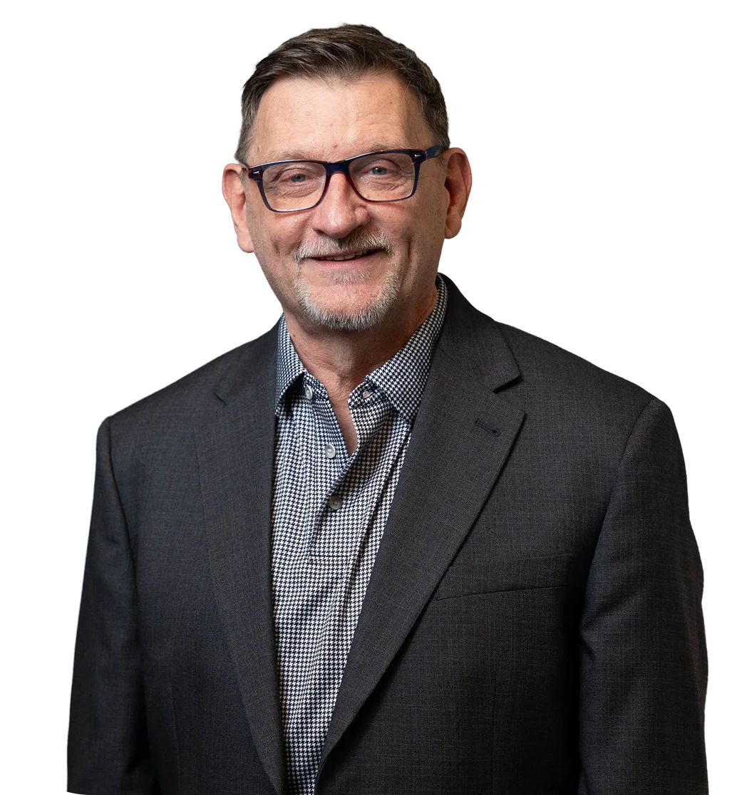 Smiling man in a suit, part of The HILL team supporting students enrolled in Cyber and Heron Virtual Academies.